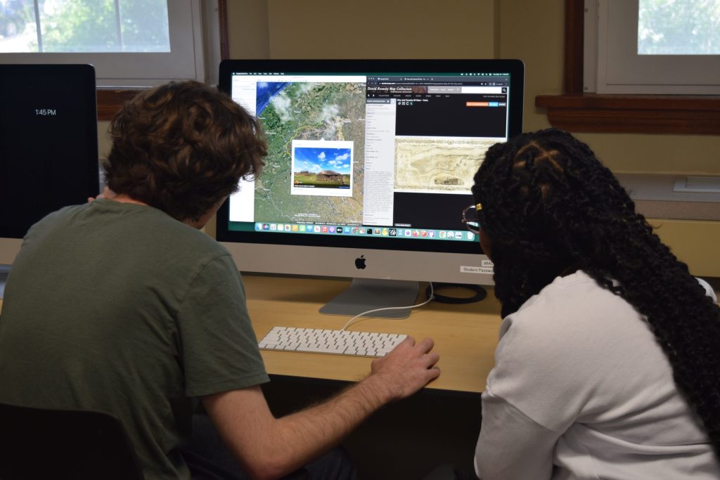two student looking a google earth on a mac
